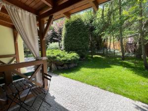 a screened in porch with a bench and a yard at WILLA BOHEMA in Łagów