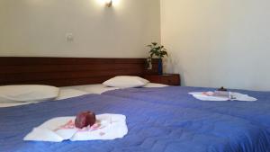 two beds with towels and food on top of them at Acropolis Hotel in Korinthos