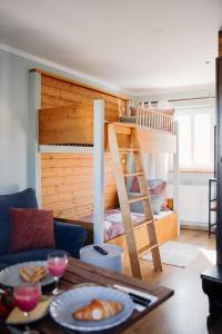 a bedroom with a bunk bed and a table with food at Pension Adele - Ruhig, direkt am Elberadweg & Badesee mit Balkon in Dresden
