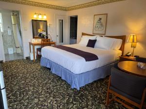 Una habitación de hotel con una cama grande y un escritorio. en Americas Best Value Inn by Sonesta, en Pecos