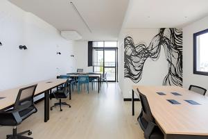 ein Büro mit Tischen und Stühlen und ein Gemälde an der Wand in der Unterkunft Apartamentos para 5 pessoas com Piscina e Academia no Centro in Curitiba + 114 Fotos