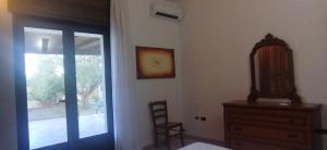 - une chambre avec un miroir, une commode et une fenêtre dans l'établissement Villetta Sakapo', à Corigliano dʼOtranto 2 autres photos