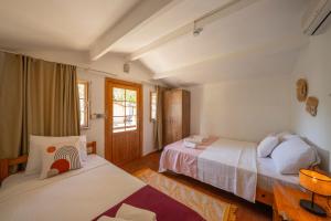 a bedroom with two beds and a window at La Dia Hotel Faralya in Fethiye