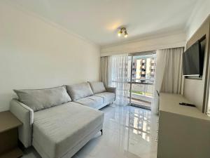 a living room with a couch and a large window at The Palace Flat Moema - UH303 in Sao Paulo