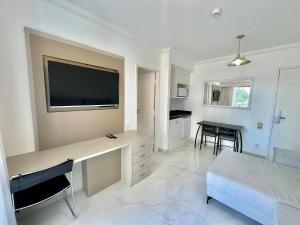 a living room with a desk with a flat screen tv at The Palace Flat Moema - UH303 in Sao Paulo