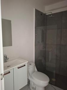 a bathroom with a white toilet and a shower at Hotel Cancún Rosa in Cancún