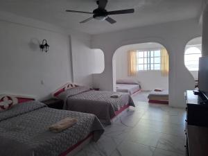 a bedroom with two beds and a ceiling fan at Hotel Cancún Rosa in Cancún
