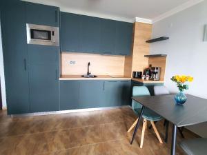 a kitchen with blue cabinets and a table at Panorama Sea View in Sveti Vlas
