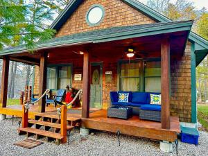 a house with a porch with blue furniture on it at NEW Beautiful Lakefront Home! 500ft of Waterfront! in Wakefield +30 photos