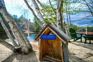 a wooden dog house with a blue sign on it at NEW Beautiful Lakefront Home! 500ft of Waterfront! in Wakefield
