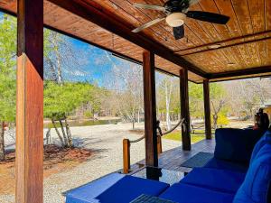 a screened in porch with a blue couch and a ceiling fan at NEW Beautiful Lakefront Home! 500ft of Waterfront! in Wakefield