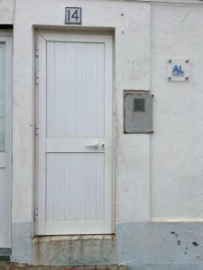 a white door on the side of a building at Quarto da casa da avó in Cercal