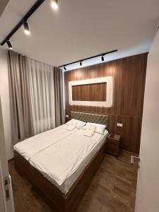 Un dormitorio con una cama grande con sábanas blancas. en Tomi Lux, en Zlatibor 9 fotos más