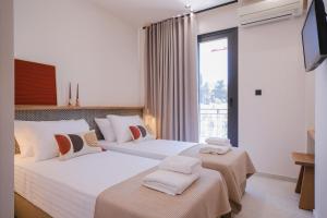 una camera d'albergo con due letti e una televisione di Casa Olivea a Polykhrono