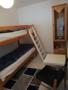 a room with two bunk beds and a desk and a chair at Ferienwohnung am Bodensee- Preiswert in Überlingen
