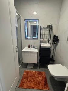 Un baño con lavabo, inodoro y espejo. en Apollo 2, en Ulcinj 7 fotos más