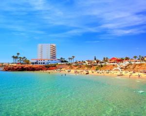 a beach with people in the water and a building at Apartment Valentino Golf 3 in Villamartin