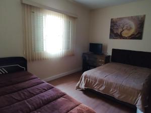 a bedroom with a bed and a window at Casa com 01 qto 42m2 in Poços de Caldas