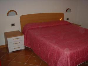 a bedroom with a red bed and a night stand at 02 Virgilio Zanetti in San Zeno di Montagna