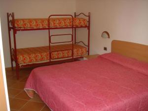 a bedroom with two bunk beds with a red bedspread at 02 Virgilio Zanetti in San Zeno di Montagna