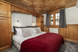 a large bed in a room with wooden walls at Farmhouse La Desmuniere in Morzine