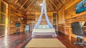 ein Schlafzimmer mit einem Bett in einem Zimmer mit Holzwänden in der Unterkunft Cabaña vista al mar y jacuzzi privado in Los Naranjos