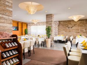 a dining room with white tables and chairs at Ózoon Hotel in Nyíregyháza