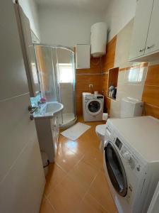 a small bathroom with a washing machine and a toilet at Barbabianca Apartment in Koper