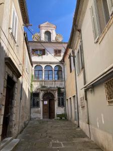an alley with a building with a clock tower at Barbabianca Apartment in Koper