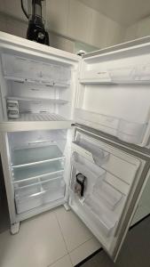 an empty refrigerator with its door open in a kitchen at Luxury 3 minutes from the Porto da Barra beach - Fast Wi-Fi, new apartment in Salvador