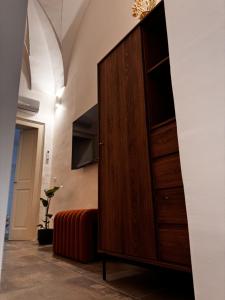 a large wooden cabinet in a room with a couch at Zephir Green in Brindisi