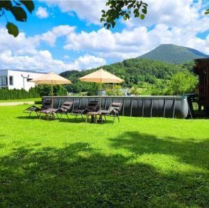 a group of tables and chairs with umbrellas on a lawn at Vikendica Mimiena in Račić