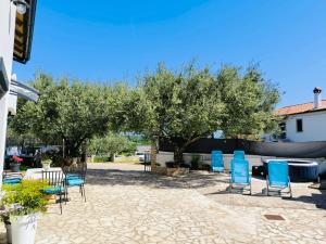 a group of chairs and tables in a yard with trees at Villa Lando in Peruški