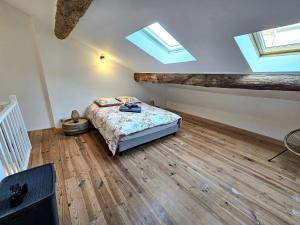 - une chambre avec un lit dans une pièce dotée de lucarnes dans l'établissement Maison de ville authentique au coeur de Leucate, à Leucate