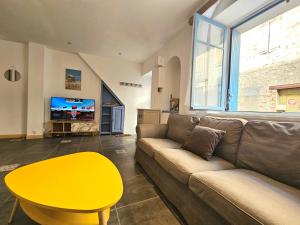 - un salon avec un canapé et une table jaune dans l'établissement Maison de ville authentique au coeur de Leucate, à Leucate