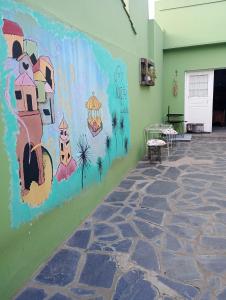 a wall with a painting on the side of a building at Aquí te Espero in Tandil
