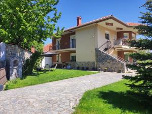 a large house with a stone driveway at Σπιτοκαλυβάκι - Sweet home in Skopiá