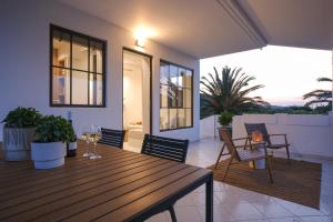 un tavolo in legno con bicchieri da vino sul balcone di Casa Olivea a Polykhrono