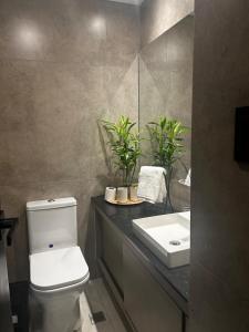 ein Badezimmer mit einer weißen Toilette und einem Waschbecken in der Unterkunft Total Comfort in Santa Cruz TC paralelo in Santa Cruz de la Sierra