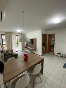 eine Küche und ein Wohnzimmer mit einem Holztisch und Stühlen in der Unterkunft Iloa Resort e residence in Barra de São Miguel