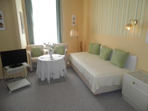 a living room with a bed and a tv and a table at Villa zur schönen Aussicht in Bad Salzuflen