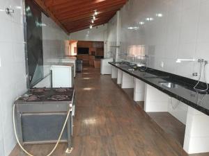 a large kitchen with a long line of counters at Chacará Kenner in Uberaba