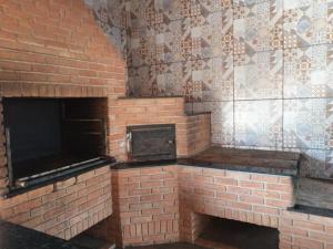 a brick oven with a brick wall in a room at Chacará Kenner in Uberaba