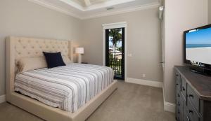 a bedroom with a bed and a flat screen tv at Hollyhock in Marco Island +23 photos