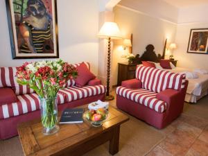 a living room with two couches and a table with flowers at Hotel Cala Sant Vicenç - Adults Only in Cala de Sant Vicenc