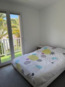 a bedroom with a bed and a sliding glass door at Duplex résidence avec piscine sur Anglet in Anglet +8 photos