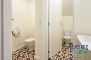 a bathroom with a toilet and a sink at Hostel Casa São Pedro - Quarto 2 in Angra do Heroísmo