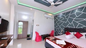 The Pavilion Beach Resort في Jāmb: غرفة نوم بسرير وكرسيين احمر