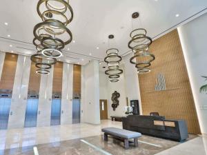 a lobby with chandeliers and a bench and a table at Boulevard Abdali view Luxury apartment in Amman +26 photos