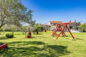 a park with a swing set in the grass at House Kacana in Vodnjan